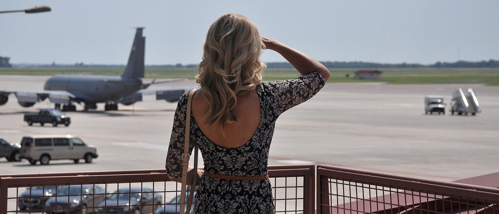 Frau schaut flugzeug hinterher